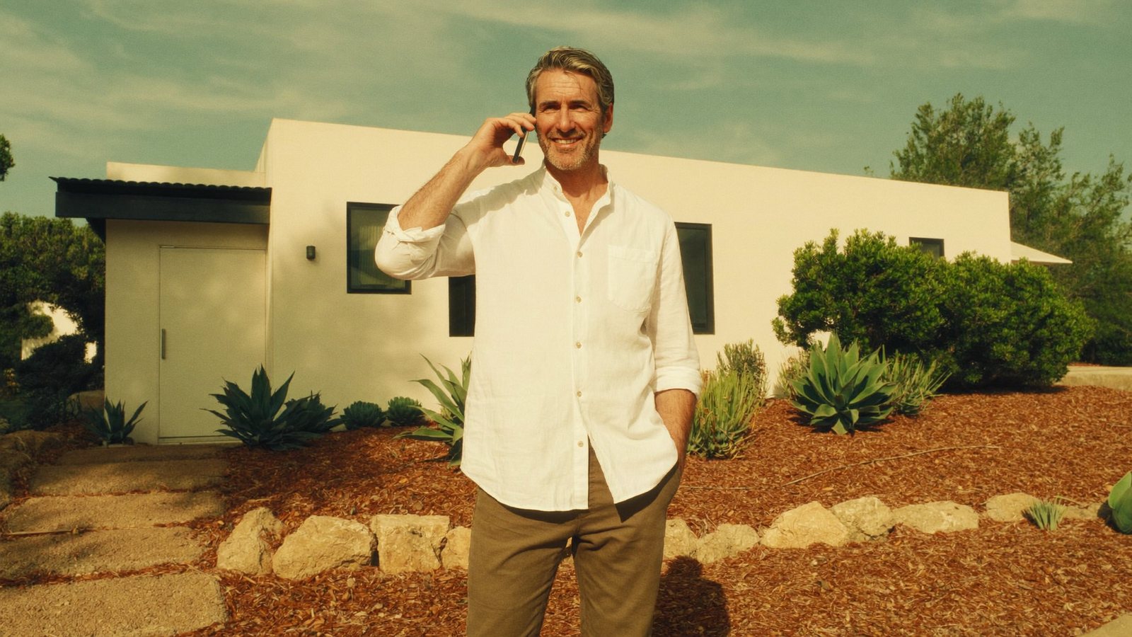 A California homeowner on a call in front of his single-story home